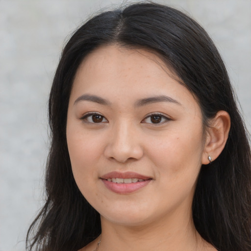 Joyful asian young-adult female with long  brown hair and brown eyes