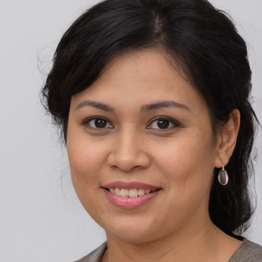 Joyful latino young-adult female with medium  brown hair and brown eyes