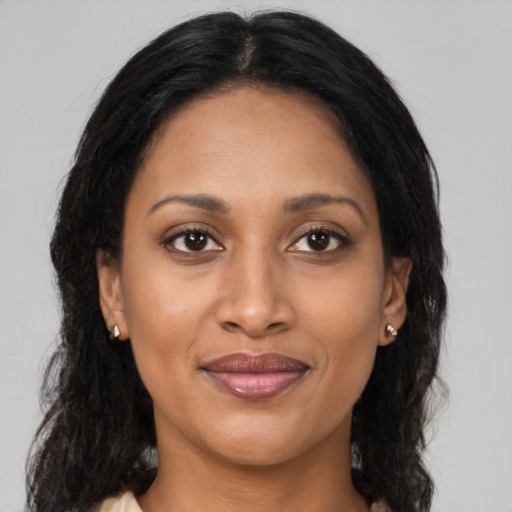 Joyful latino adult female with long  brown hair and brown eyes