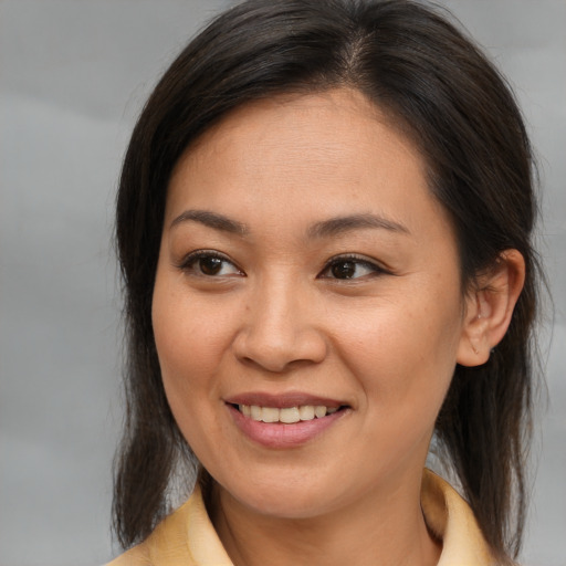 Joyful asian young-adult female with medium  brown hair and brown eyes