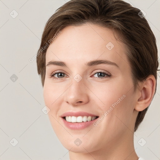 Joyful white young-adult female with short  brown hair and grey eyes