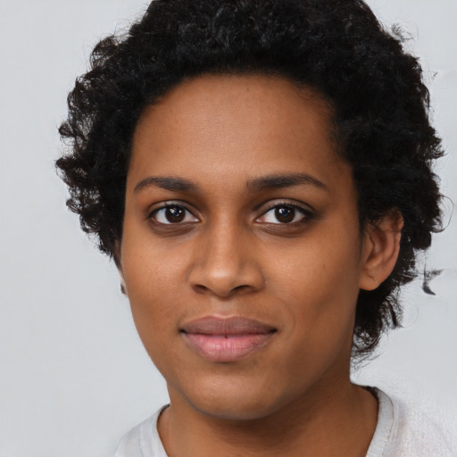 Joyful black young-adult female with short  black hair and brown eyes
