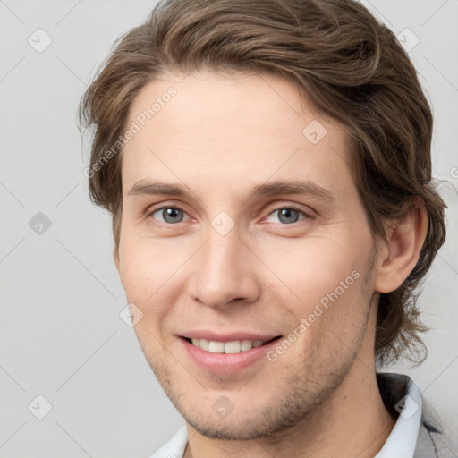 Joyful white young-adult male with medium  brown hair and grey eyes