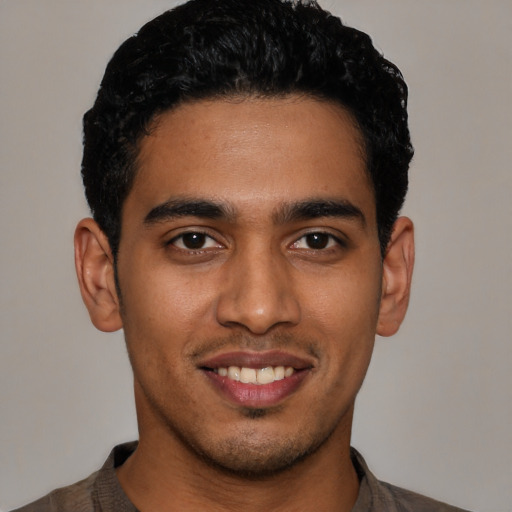 Joyful latino young-adult male with short  black hair and brown eyes