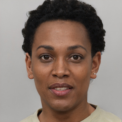 Joyful black young-adult female with short  black hair and brown eyes