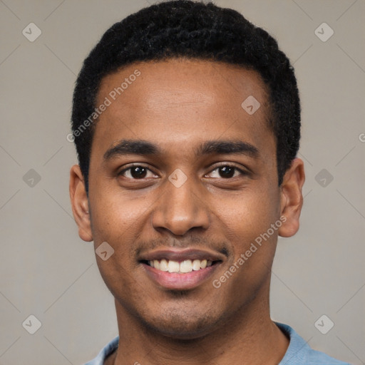 Joyful black young-adult male with short  black hair and brown eyes