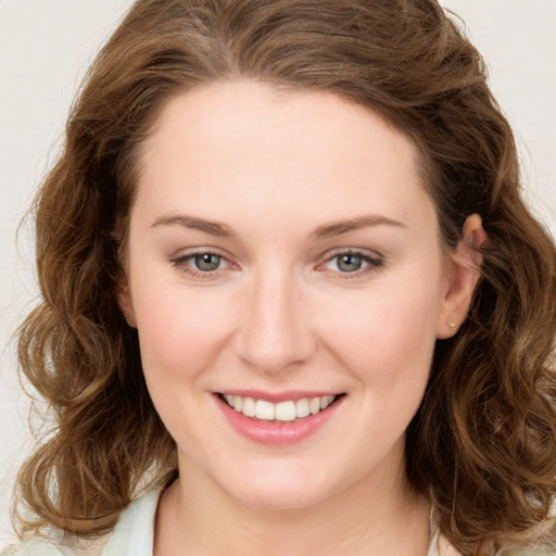 Joyful white young-adult female with long  brown hair and green eyes