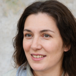 Joyful white adult female with long  brown hair and brown eyes