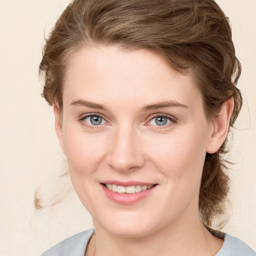 Joyful white young-adult female with medium  brown hair and blue eyes