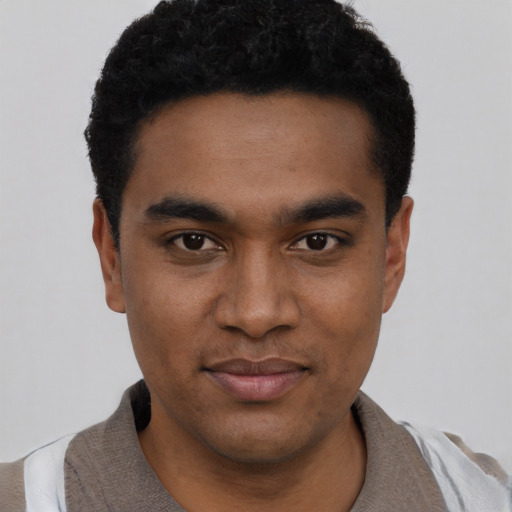 Joyful black young-adult male with short  black hair and brown eyes