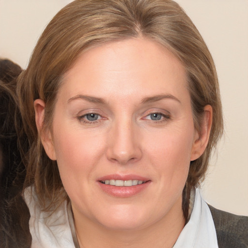 Joyful white adult female with medium  brown hair and blue eyes