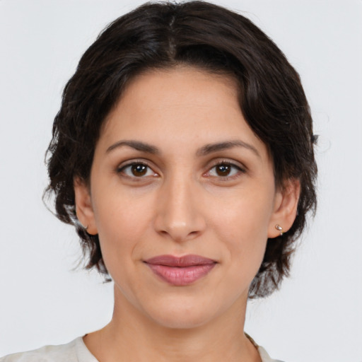 Joyful latino young-adult female with medium  brown hair and brown eyes