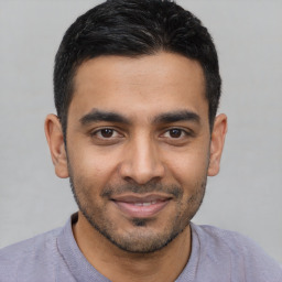 Joyful latino young-adult male with short  black hair and brown eyes