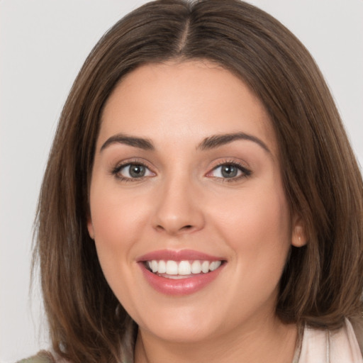 Joyful white young-adult female with medium  brown hair and green eyes