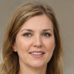 Joyful white young-adult female with long  brown hair and green eyes