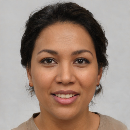Joyful latino young-adult female with medium  brown hair and brown eyes