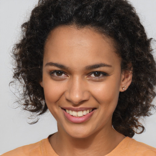 Joyful black young-adult female with medium  brown hair and brown eyes