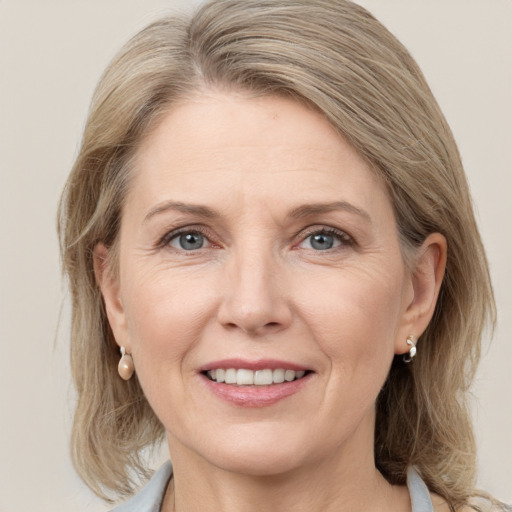 Joyful white adult female with medium  brown hair and grey eyes