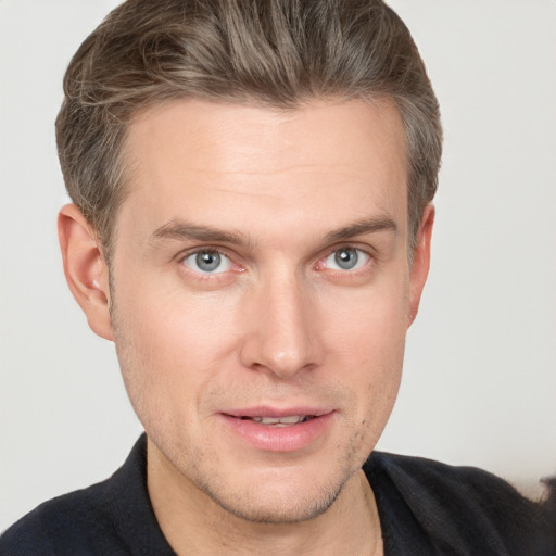 Joyful white young-adult male with short  brown hair and grey eyes