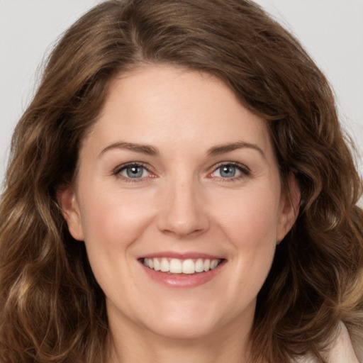 Joyful white young-adult female with long  brown hair and green eyes