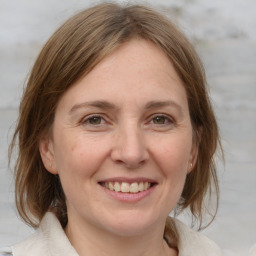 Joyful white adult female with medium  brown hair and grey eyes