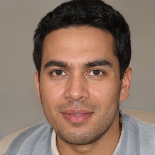 Joyful white young-adult male with short  black hair and brown eyes