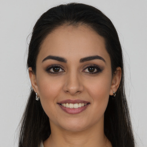 Joyful latino young-adult female with long  brown hair and brown eyes