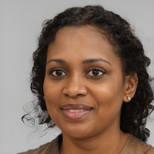 Joyful black young-adult female with medium  brown hair and brown eyes