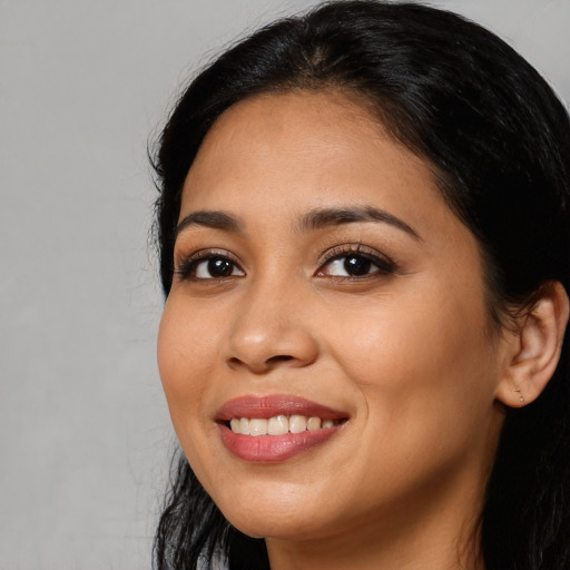 Joyful latino young-adult female with long  black hair and brown eyes