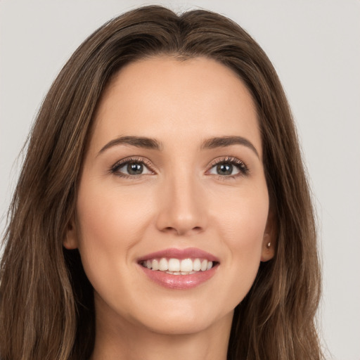 Joyful white young-adult female with long  brown hair and brown eyes