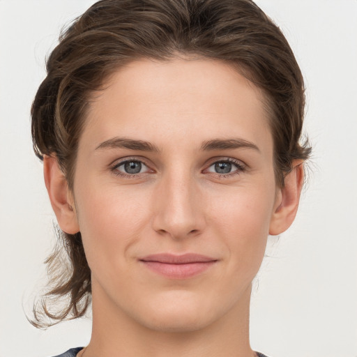 Joyful white young-adult female with medium  brown hair and grey eyes