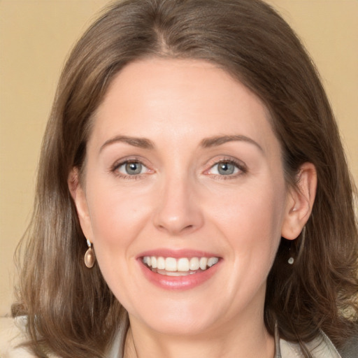 Joyful white adult female with medium  brown hair and grey eyes