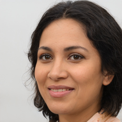 Joyful latino adult female with medium  brown hair and brown eyes