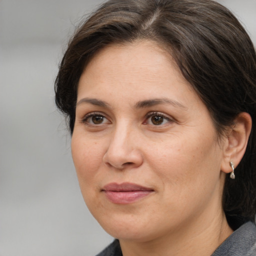 Joyful white adult female with medium  brown hair and brown eyes