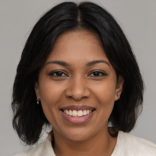 Joyful black young-adult female with medium  black hair and brown eyes