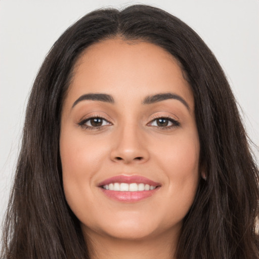 Joyful white young-adult female with long  brown hair and brown eyes