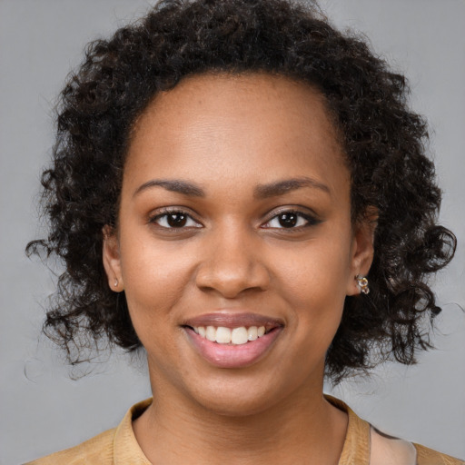 Joyful black young-adult female with long  brown hair and brown eyes