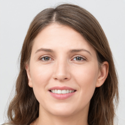 Joyful white young-adult female with long  brown hair and grey eyes