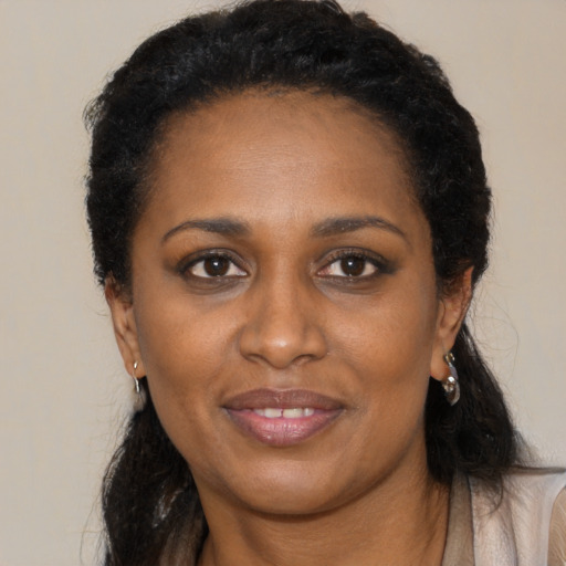 Joyful black young-adult female with long  black hair and brown eyes
