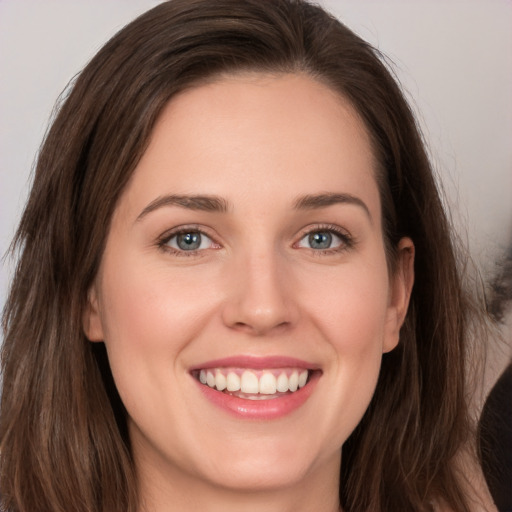 Joyful white young-adult female with long  brown hair and brown eyes