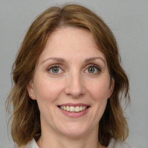 Joyful white young-adult female with medium  brown hair and green eyes