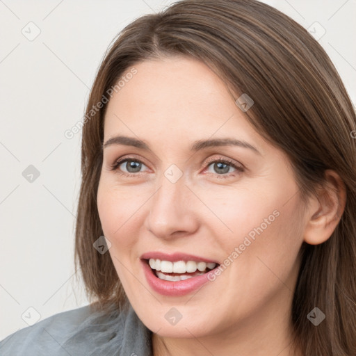 Joyful white young-adult female with long  brown hair and grey eyes