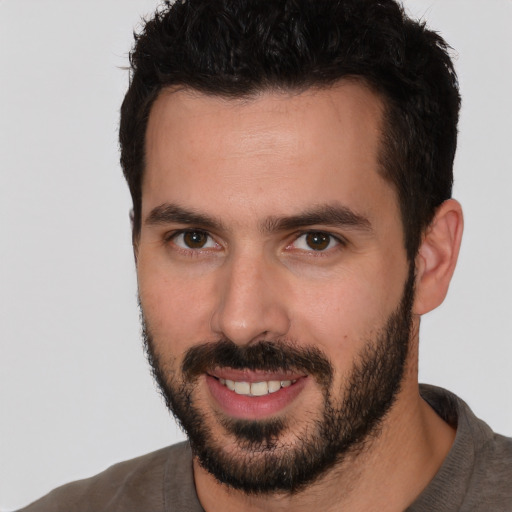 Joyful white young-adult male with short  black hair and brown eyes