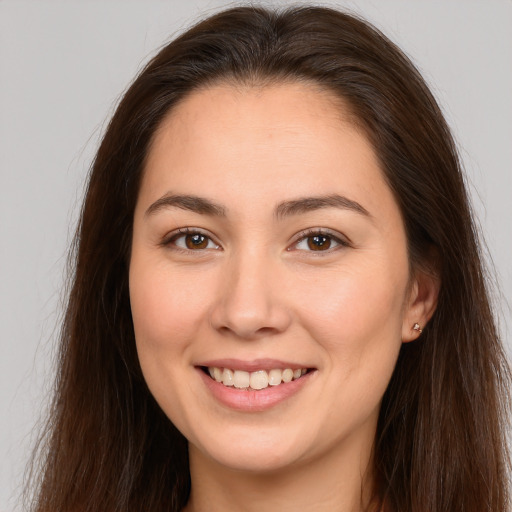 Joyful white young-adult female with long  brown hair and brown eyes