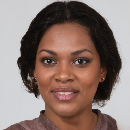 Joyful black young-adult female with medium  brown hair and brown eyes