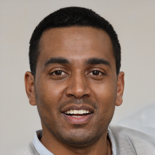 Joyful black young-adult male with short  black hair and brown eyes