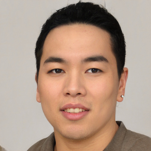 Joyful asian young-adult male with short  black hair and brown eyes