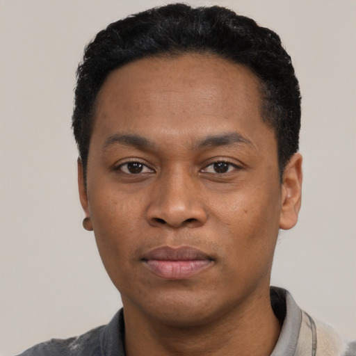 Joyful black young-adult male with short  black hair and brown eyes