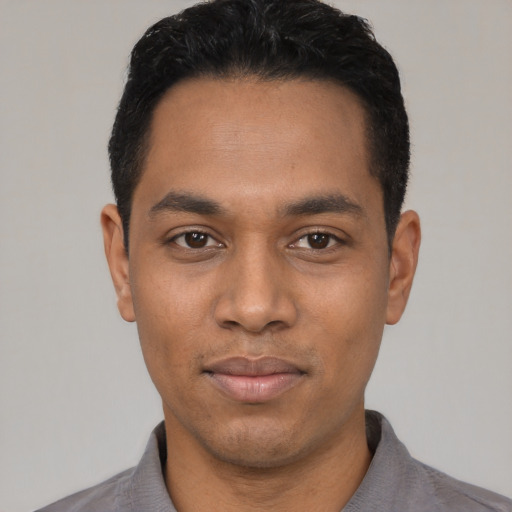 Joyful latino young-adult male with short  black hair and brown eyes