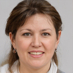 Joyful white adult female with medium  brown hair and grey eyes